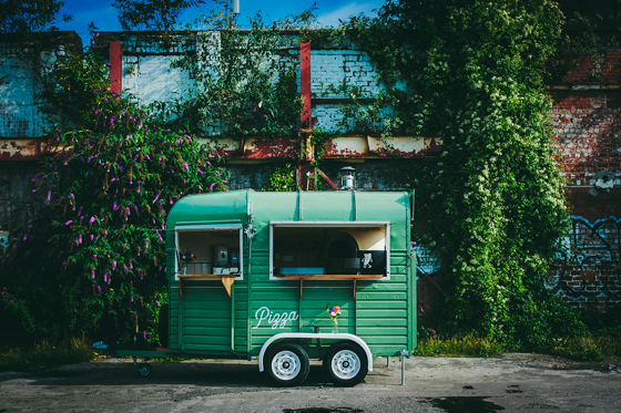 Green Dough Man's Land horsebox in front of leafy, floral background